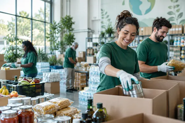 Volunteers organizing food and essential supplies in a well-run community distribution center